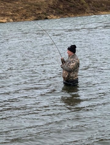 Veiðimaður með fisk á í opnunarholli Miðsvæðisins 2026"