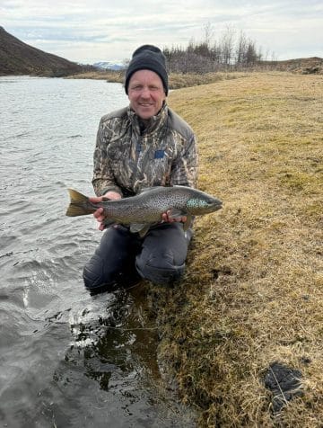 Veiðimaður með stóran urriða í opnunarholli Miðsvæðisins 2026"